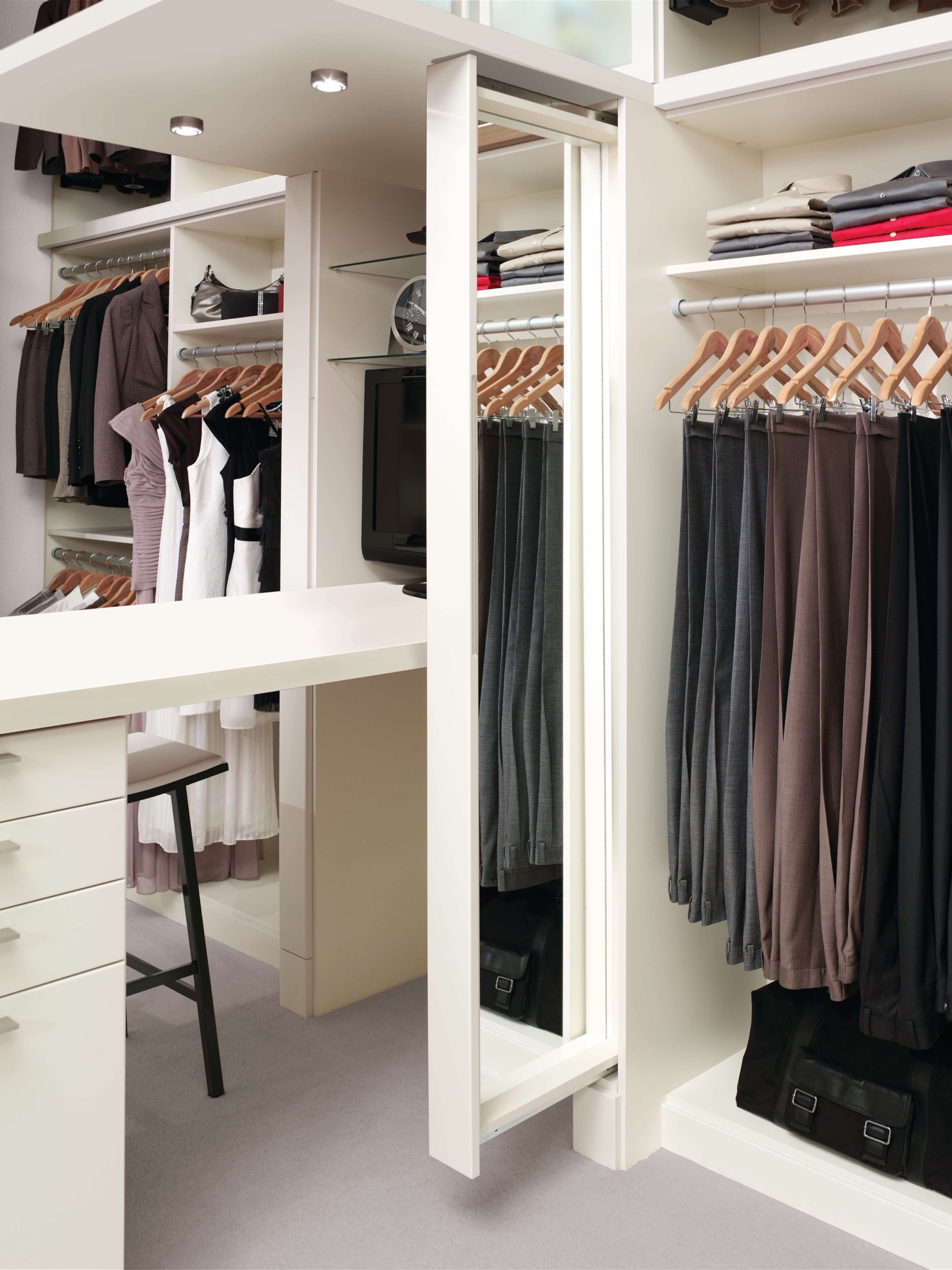 Custom white walk-in closet with center island, vanity, and lighting in a Delaware home