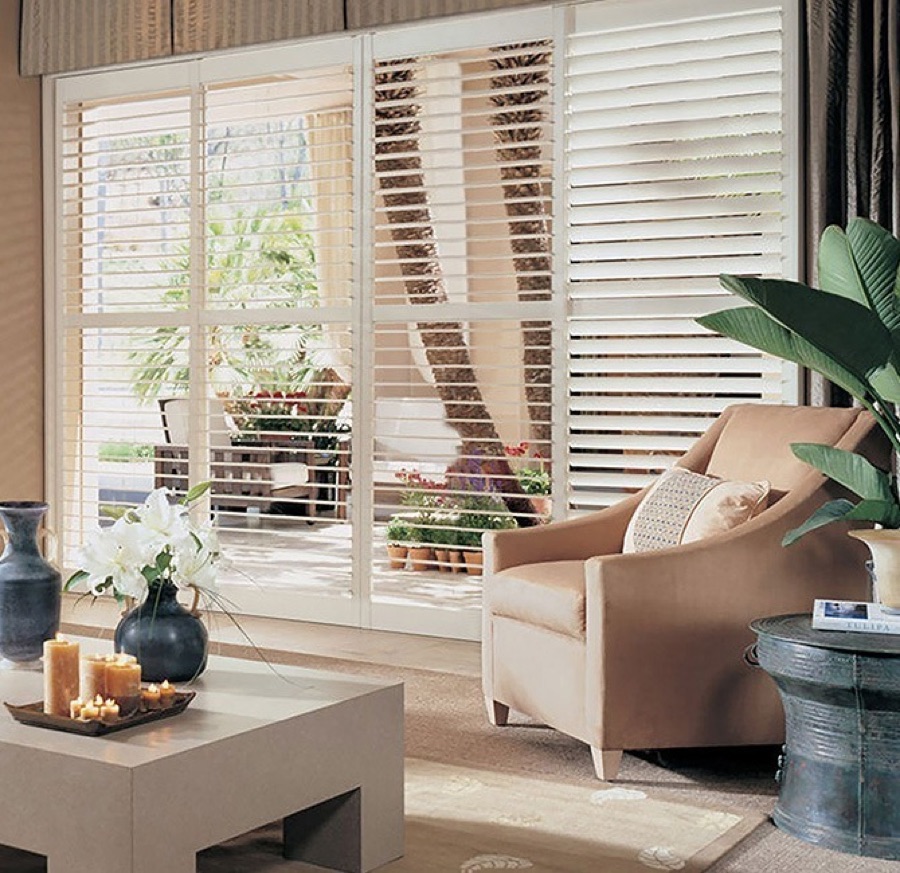 White Wynhaven plantation shutters spanning a wide patio door on a bypass track